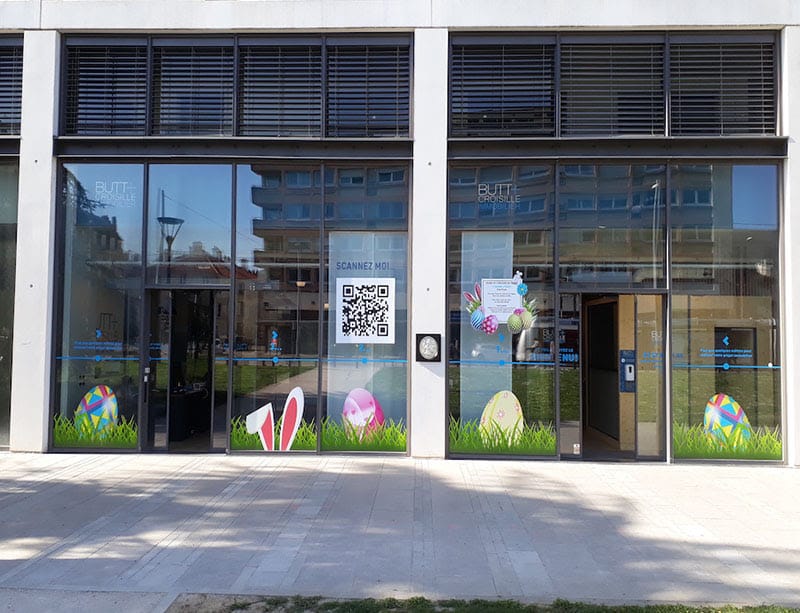 Stickers sur la vitrine de l'agence immobilière Butt + Croisille à Nancy représentant des lapins et des oeufs de pâques cachés dans l'herbe